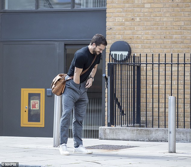 Reshuffle: The Game Of Thrones star, 33, hung back from his wife and their pooch as he stuffed his arm down the front of his slacks to deal with whatever issue was aggravating him